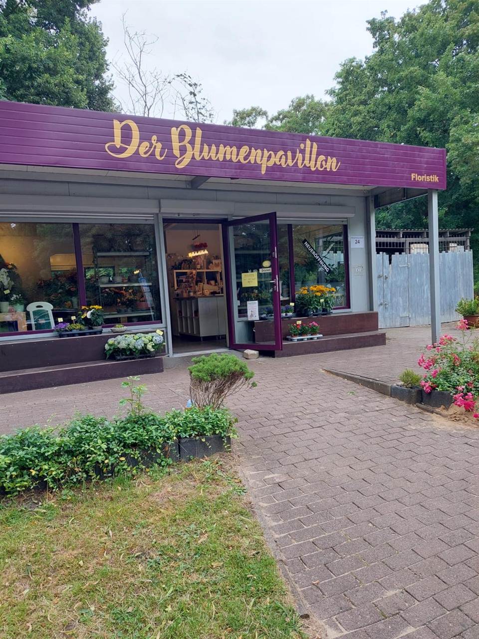 Ladenansicht mit frischen Blumen und liebevoller Dekoration